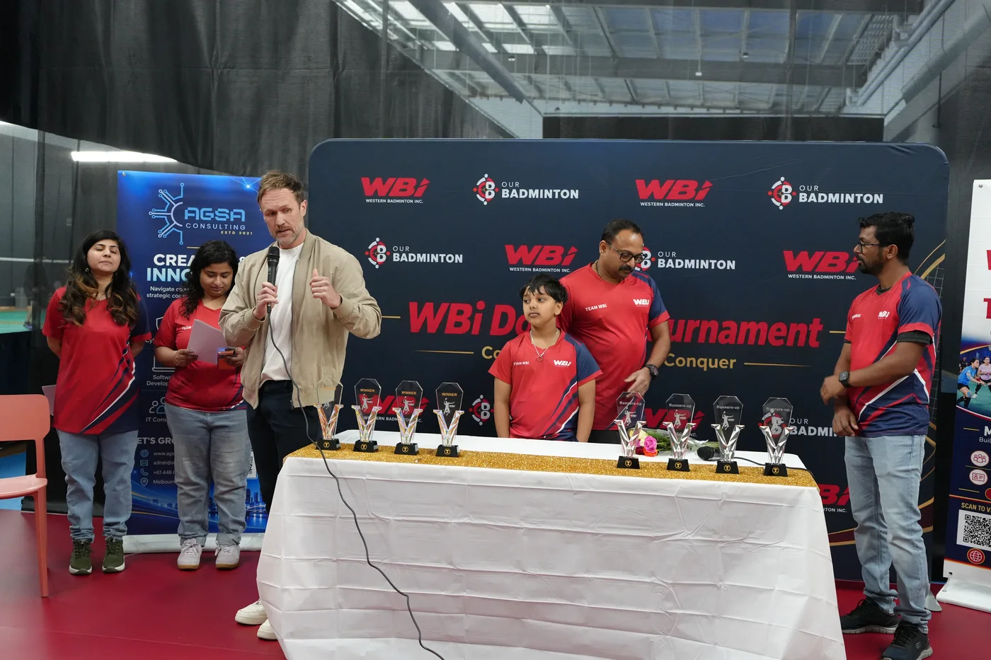 Clint addressing the tournament beside Team WBi and the trophy table