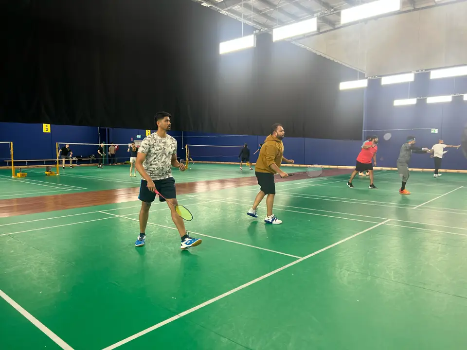 Players wearing sports shoes while moving on an indoor badminton court at a WBi social session