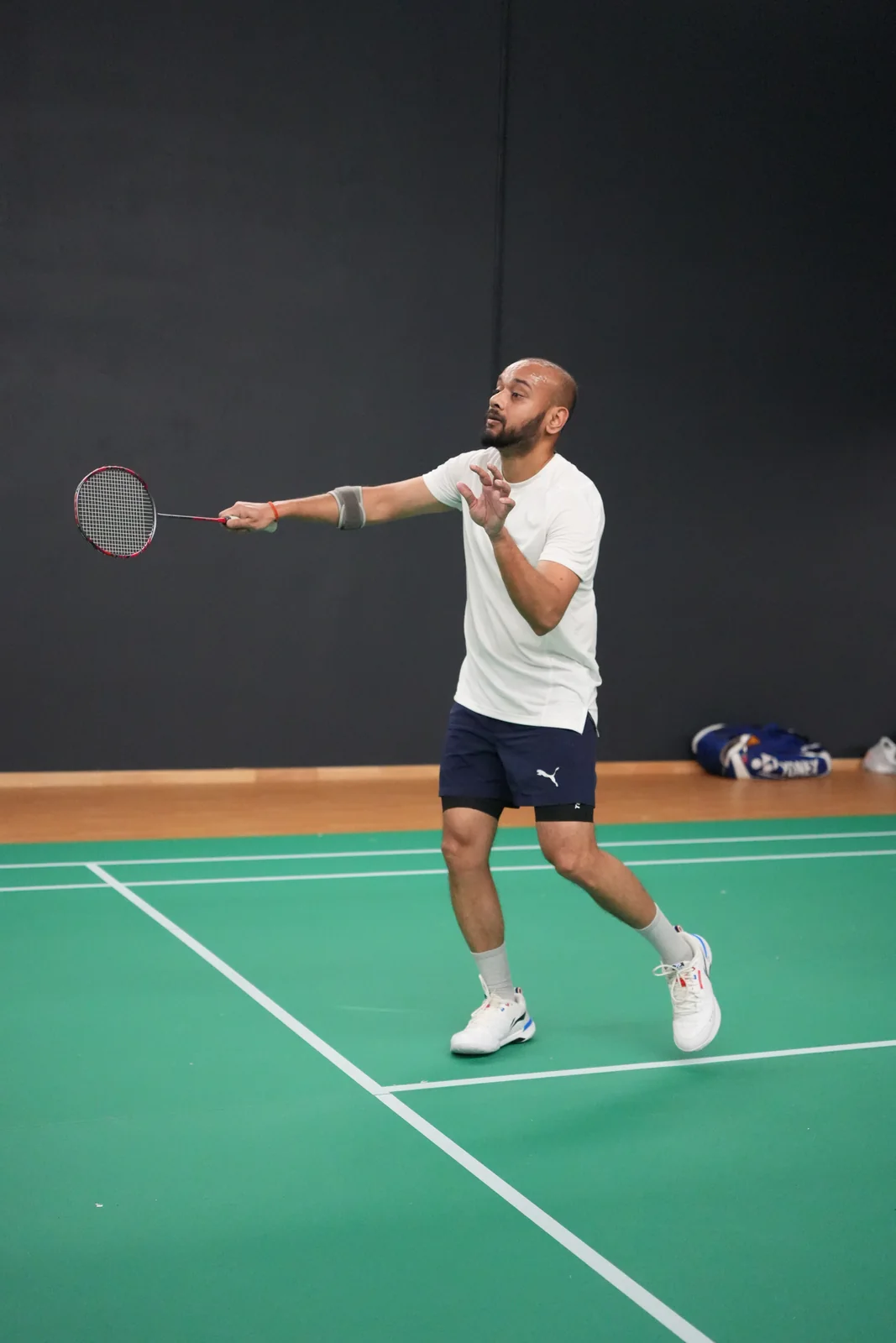 A player in a white shirt reaching forward with a racket on court at the WBi 2026 tournament