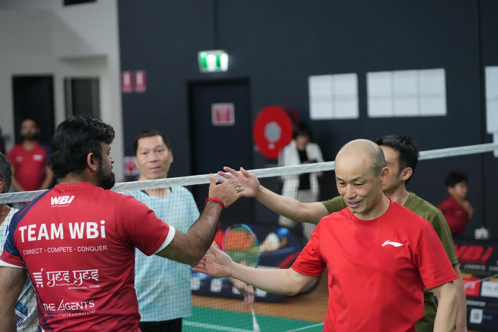 Players sharing a high-five across the net at the WBi Flagship Doubles Tournament 2026